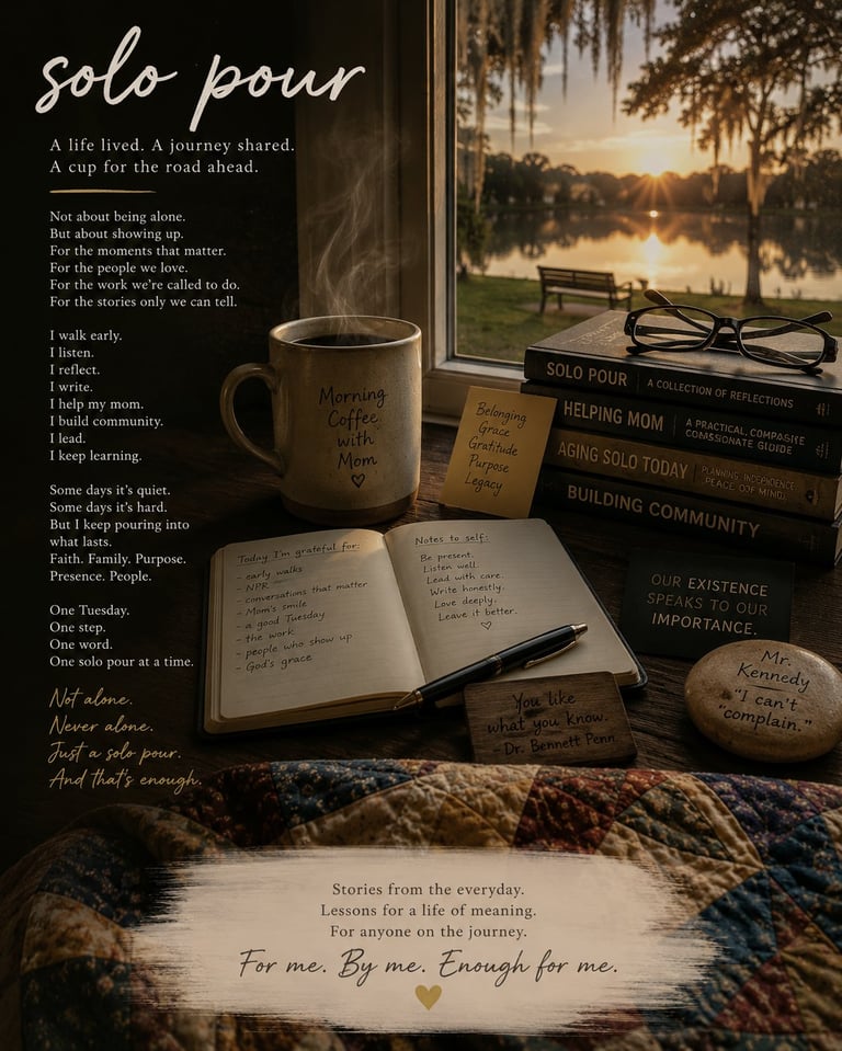 A windowsill display featuring an open journal, steaming mug labeled Morning Coffee, stacked books about community, and stones with inspirational words, overlooking a sunset lake view